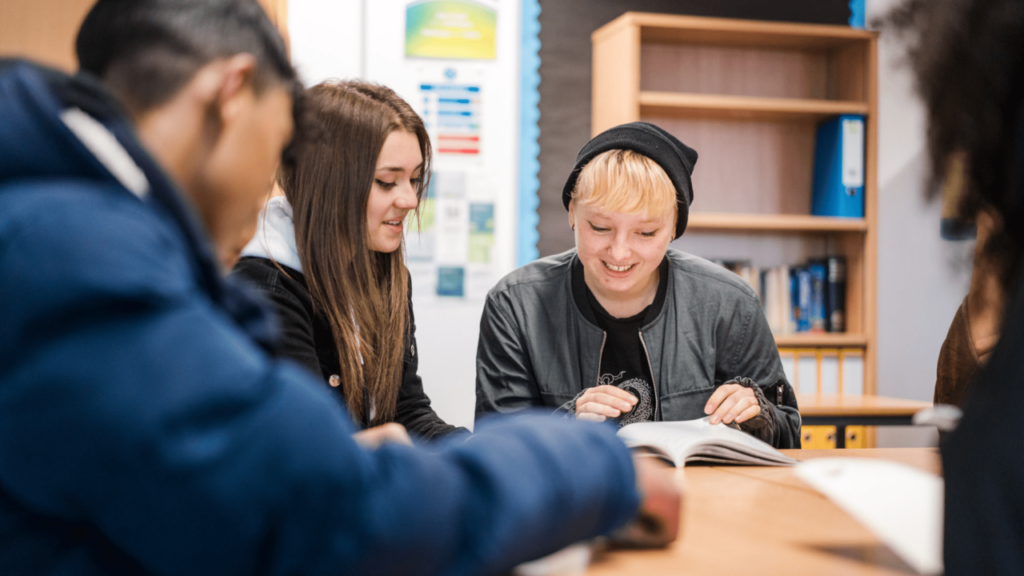 A group of students sitting around a table working from their textbooks